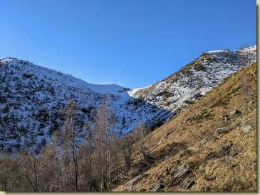 fuori dal bosco, a sinistra il Becco della Guardia...